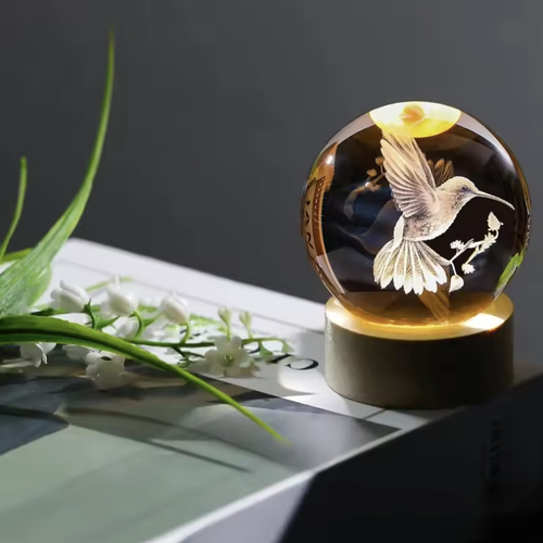 Lampe à poser boule colibri posée sur un livre Image