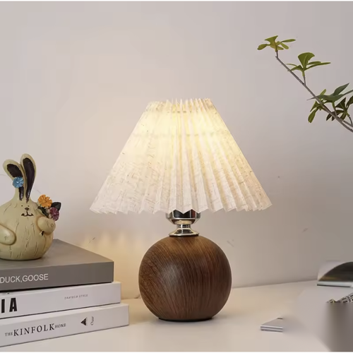 Lampe à poser boule effet bois avec abat-jour plissé sur un bureau
