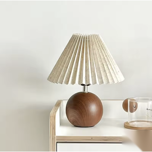 Lampe à poser boule effet bois avec abat-jour plissé sur une console Image