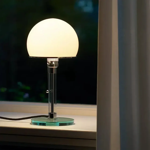 Lampe à poser dôme opaline design Bauhaus allumée près d'une fenêtre